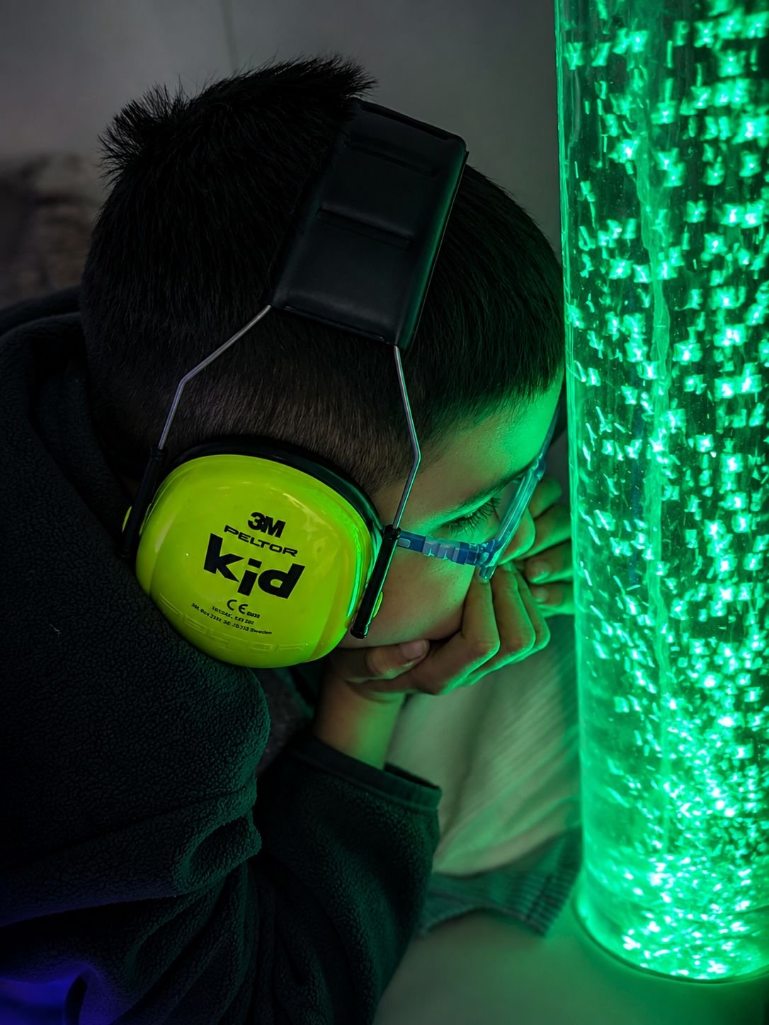 Niño observando una columna de burbujas iluminada durante una experiencia JACE