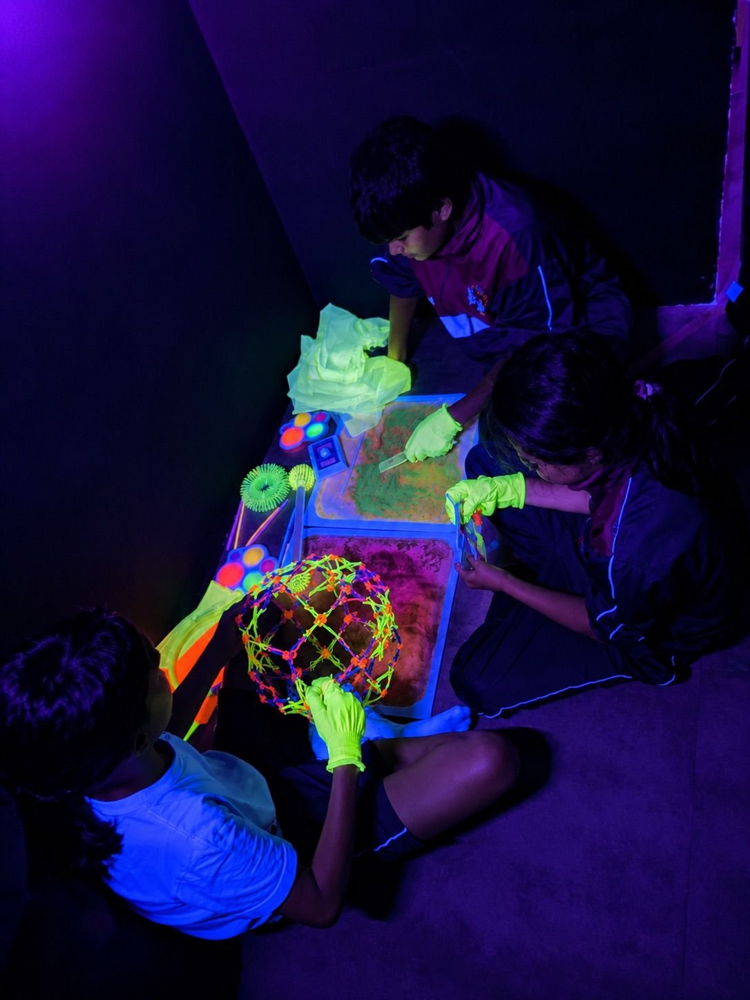 Actividad sensorial de JACE con materiales fluorescentes bajo luz ultravioleta